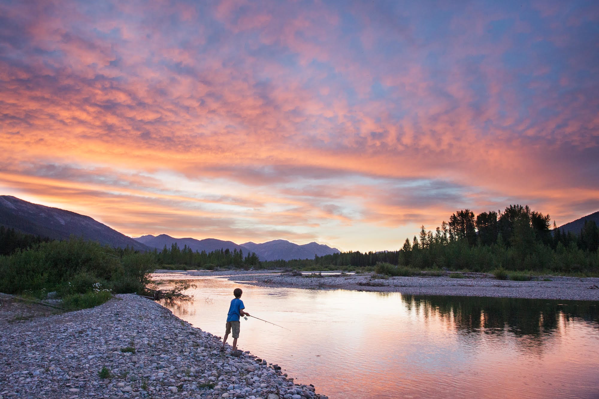 Silas Teasdale fishes the sunset on Montana's North Fork Flathead River. The area is a drainage connected to lakes that were treated with rotenone. © Aaron Teasdale for Public Herald